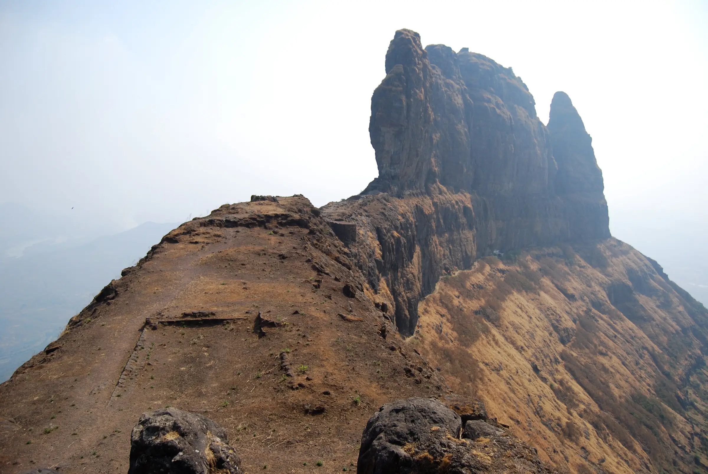 The narrow Sone Machi ridge of Malanggad with fort-wall remains, leading to the sheer rock pinnacles of the Balekilla
