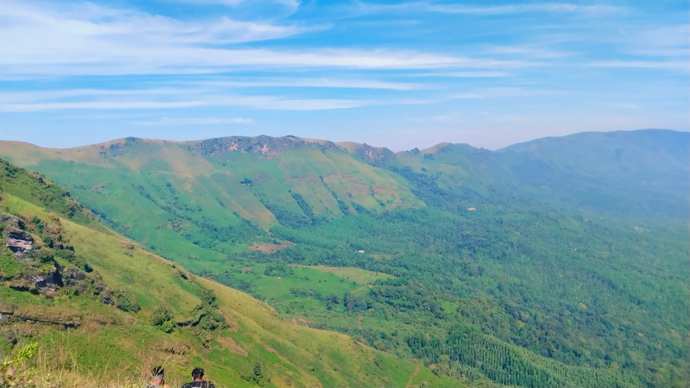 Green grass slopes and rocky ridges of the Chandradrona range seen from the Deviramma Betta trail