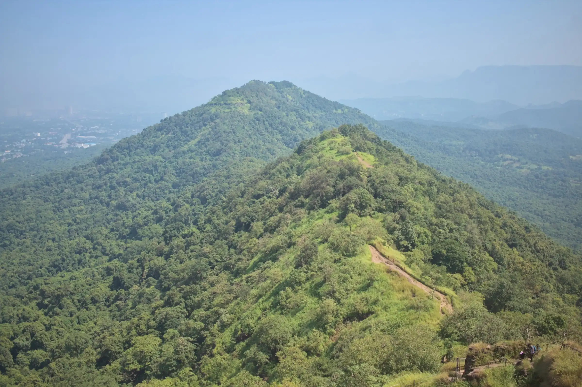 Forested hills of Karnala Bird Sanctuary seen from the fort, with a trail along the green ridge