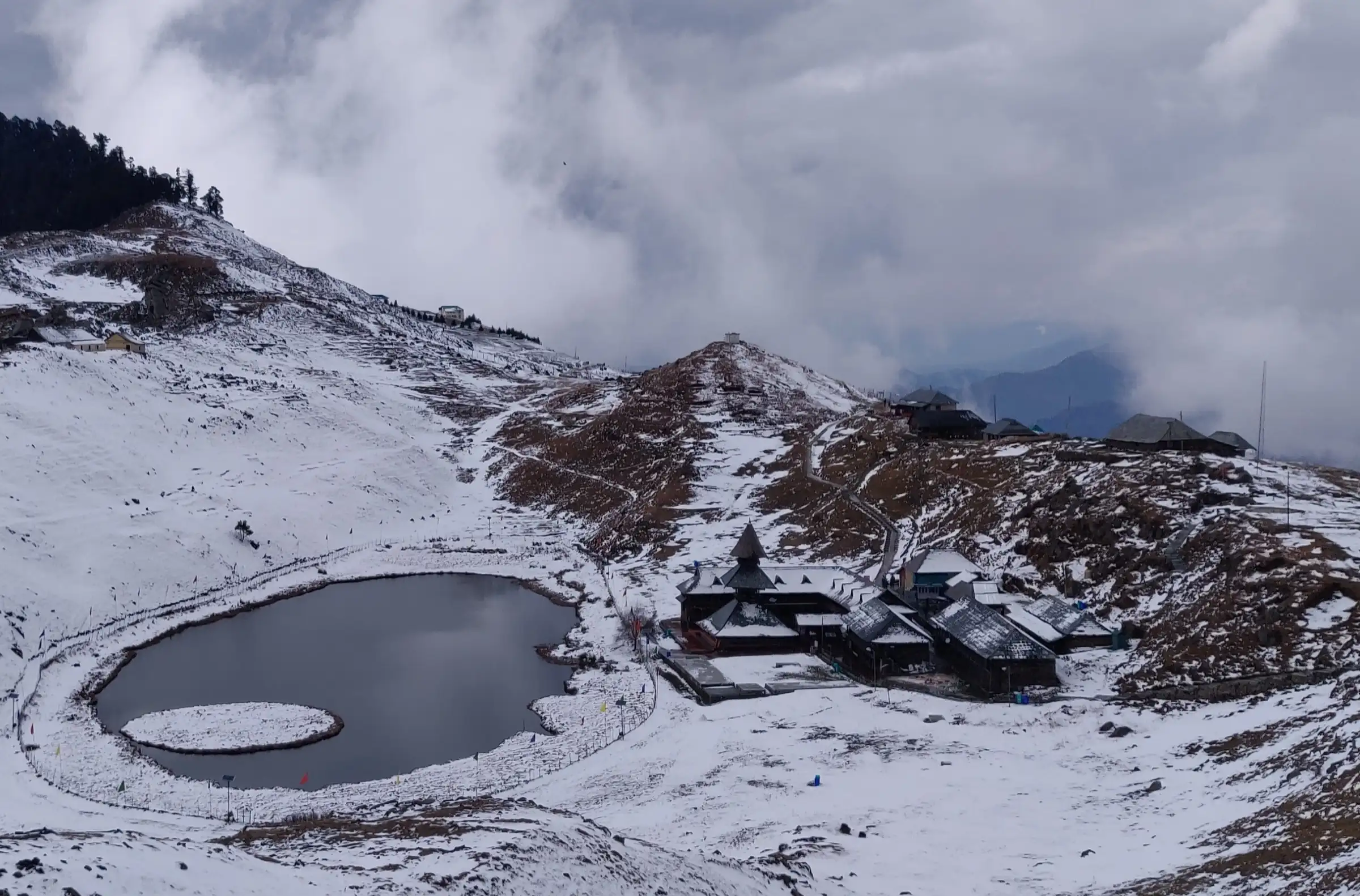Prashar Lake and the pagoda-roofed temple of Maharishi Parashar surrounded by fresh snow in December